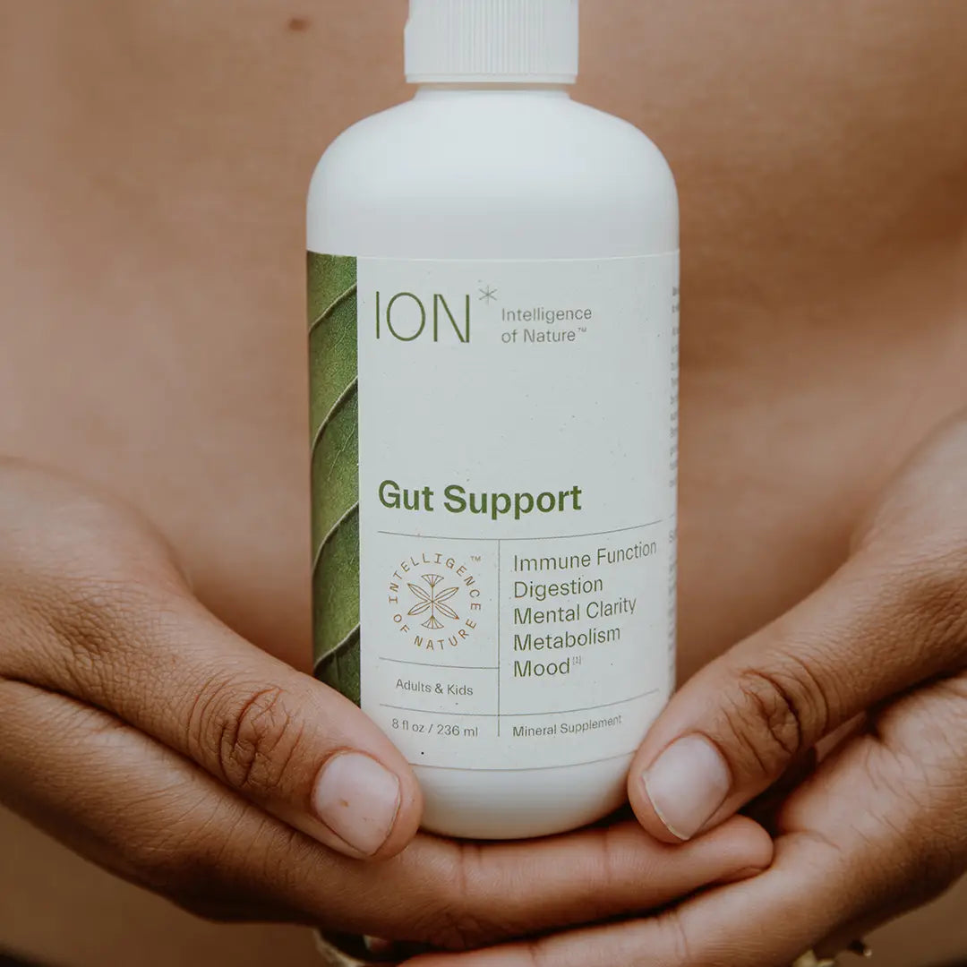 ION* Gut Support product bottle being held up by female hands.